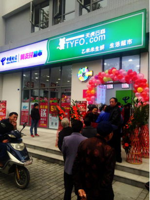 社区居民在“中国电信翼支付·天虎云商乙米米生鲜O2O生活超市”门口排队体验